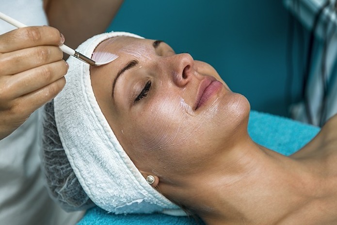 Woman posing with her hands on her face excentuating her dermal fillers and injections.